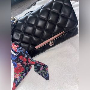 A Steve Madden crossbody black leather purse, a scarf on the side with keychain